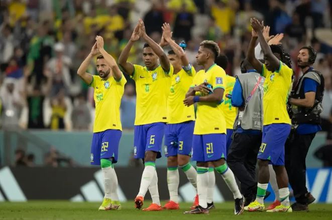 Os jogadores de futebol do Brasil aplaudem em campo.