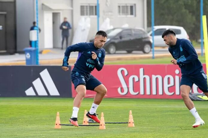 Dois jogadores de futebol da Argentina estão correndo em um treino.