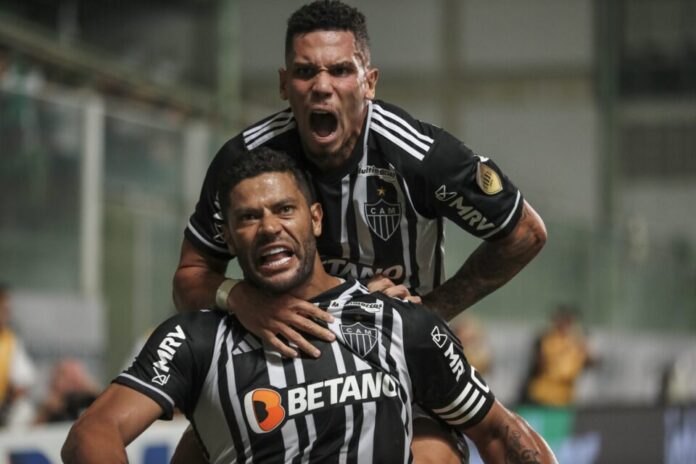 Dois jogadores de futebol do Atlético Mineiro comemorando após marcar gol contra o Cuiabá pelo Campeonato Brasileiro.